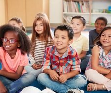 Elementary students sitting together on a classroom rug
